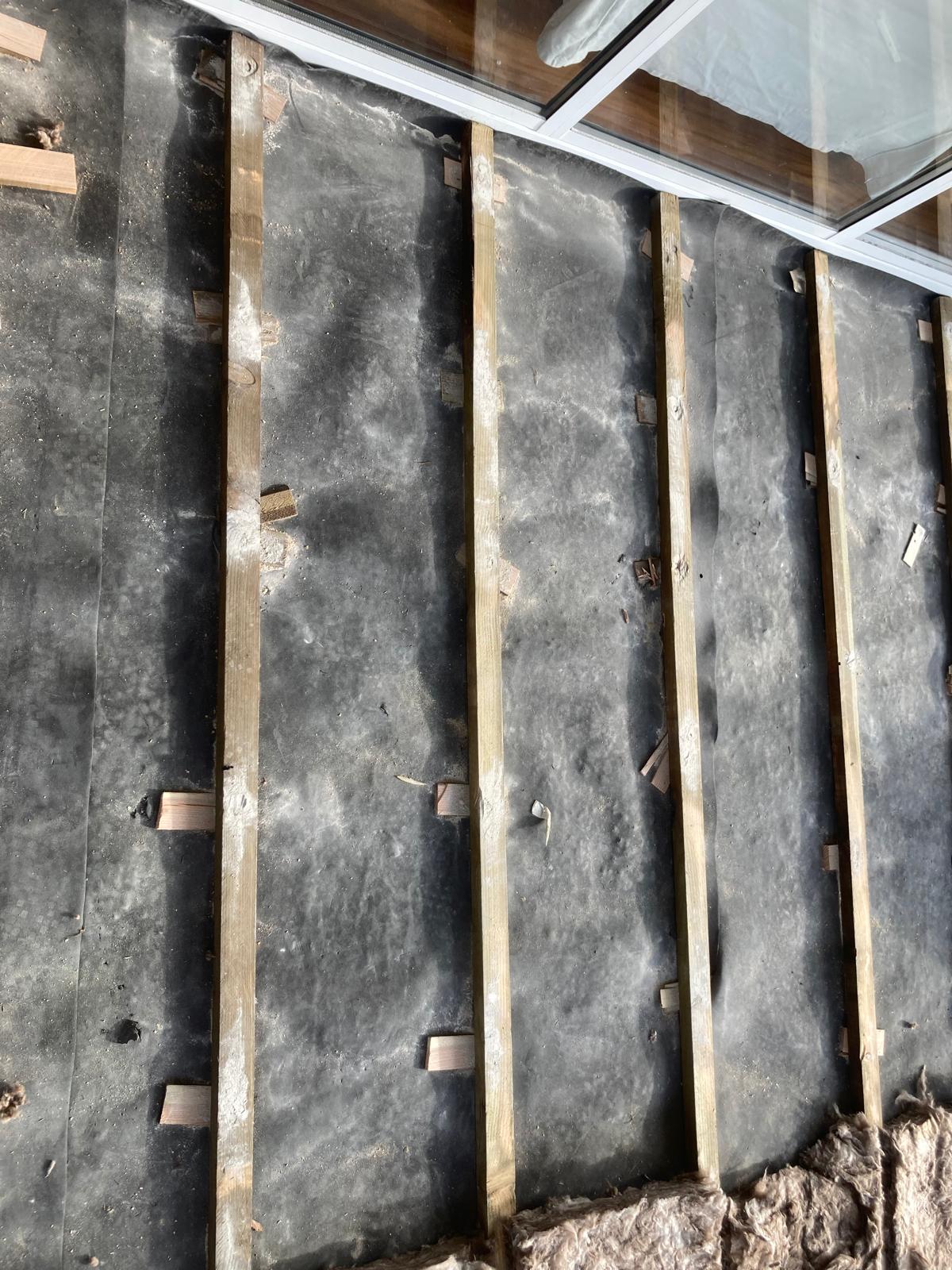 Técnico instalando aislante térmico y acústico antes de colocar tarima flotante